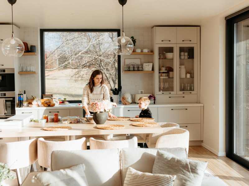 Designer d'intérieur présentant des échantillons de matériaux et plans d'agencement sur une table